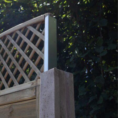 A pair of Fencemate trellis extension brackets being used to secure a wooden lattice trellis to a concrete fence post. The galvanised steel brackets slide into the post's channel, allowing for easy height extension of an existing fence.