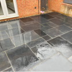 Black limestone patio pack laid in a modern patio against a brick house